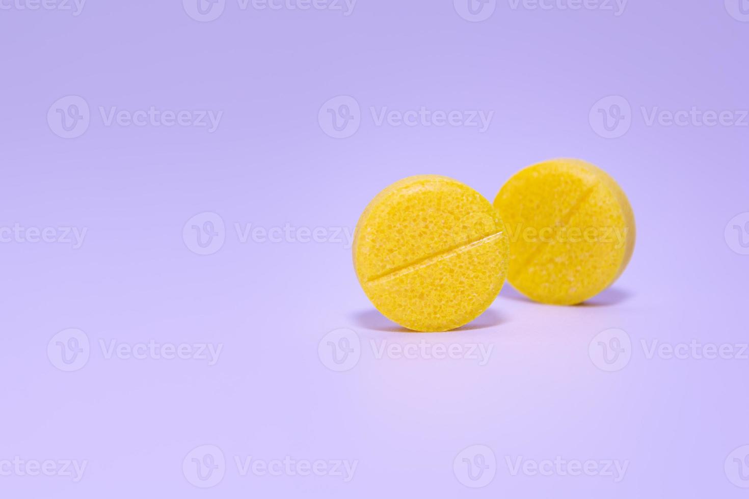 Yellow pills on purple background photo