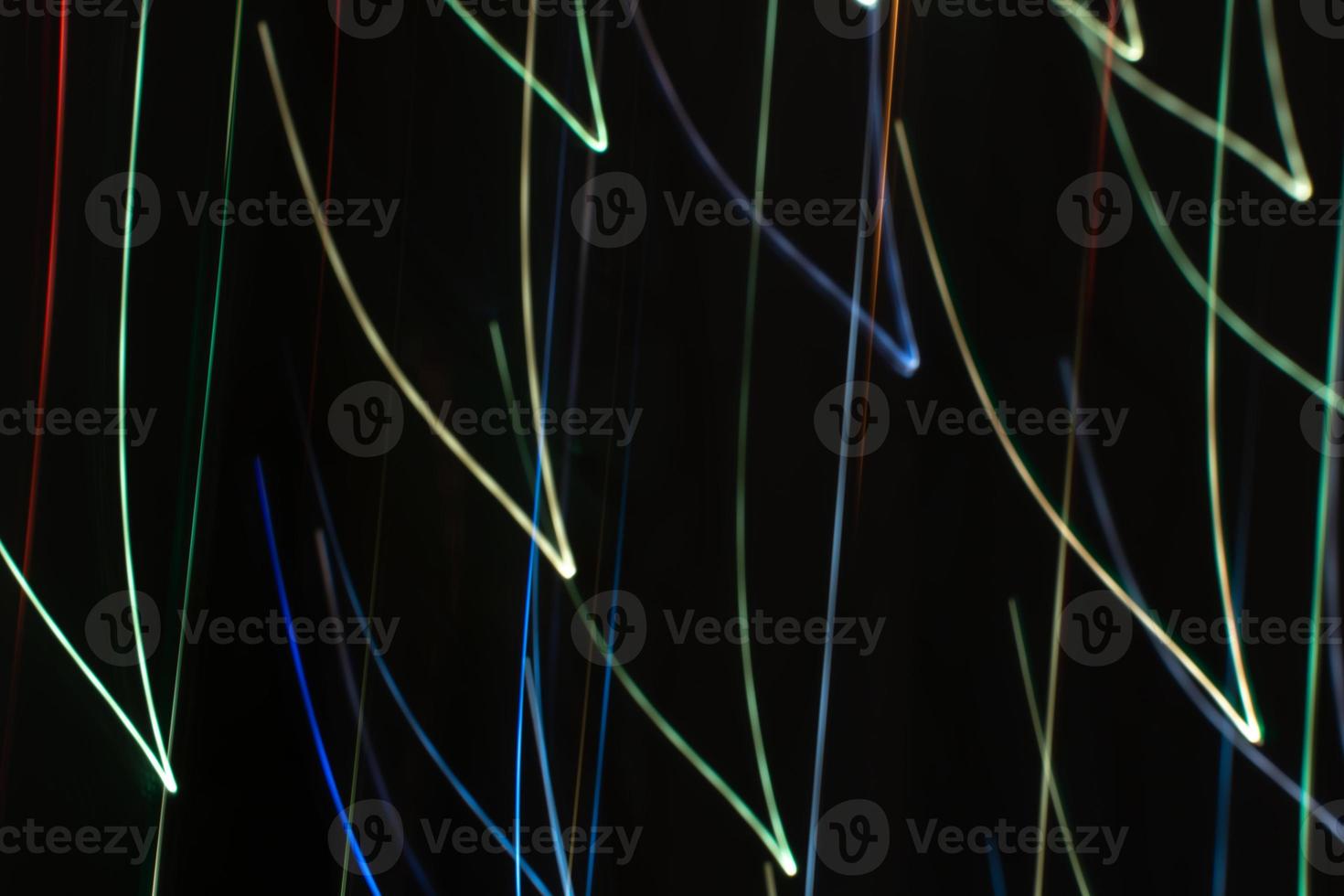 Bright multicolored diagonal V shaped beams of glare on black in cool tones. Abstract background photo