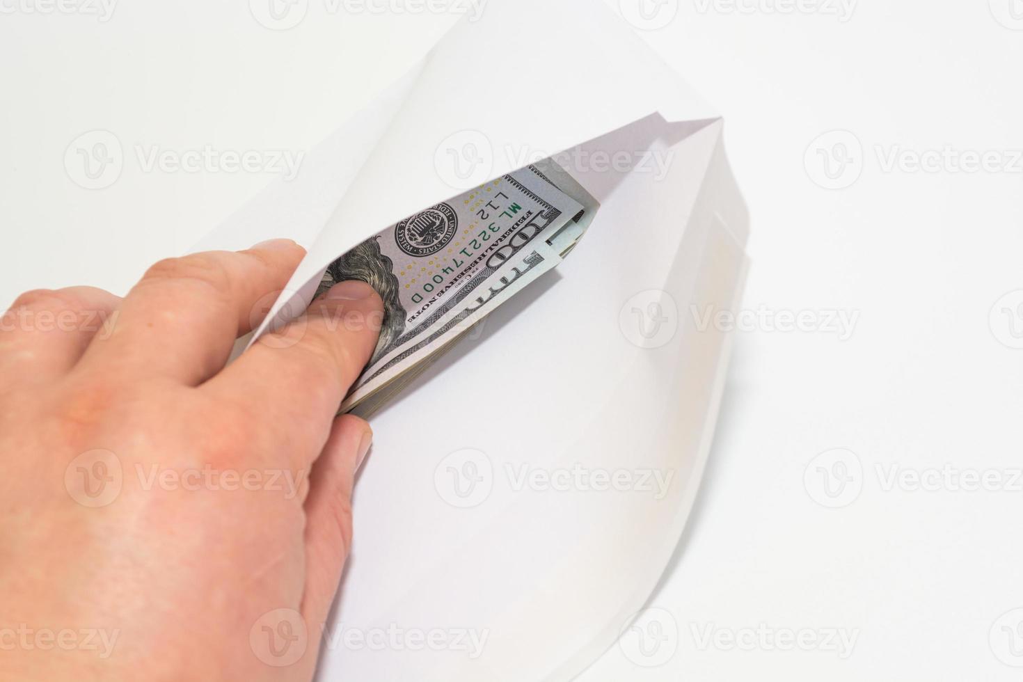 A man takes out money dollars from a white envelope photo