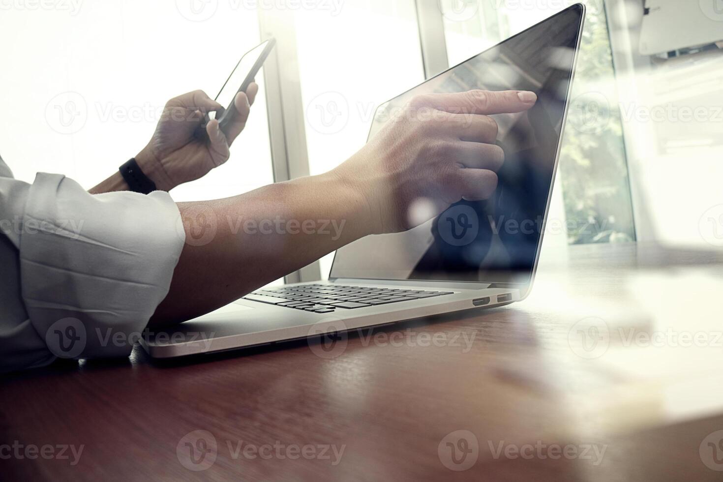 designer hand working and smart phone and laptop on wooden desk in office background with social network diagram photo