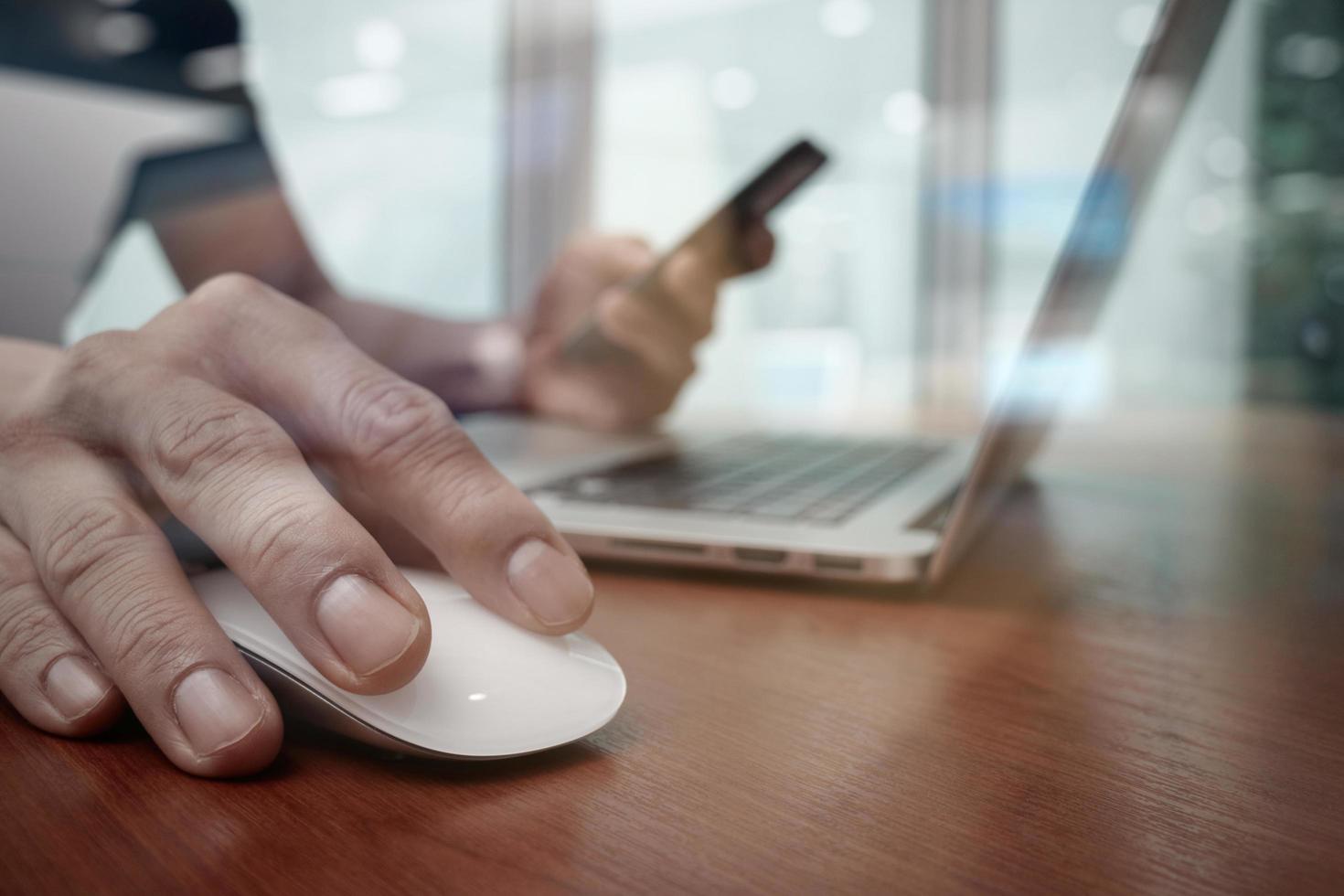 business man hand working on laptop computer on wooden desk photo