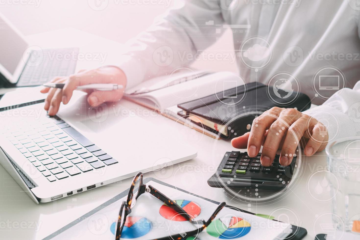 mano de hombre de negocios trabajando con finanzas sobre costos y calcular y latop con teléfono móvil en el escritorio en la oficina moderna foto