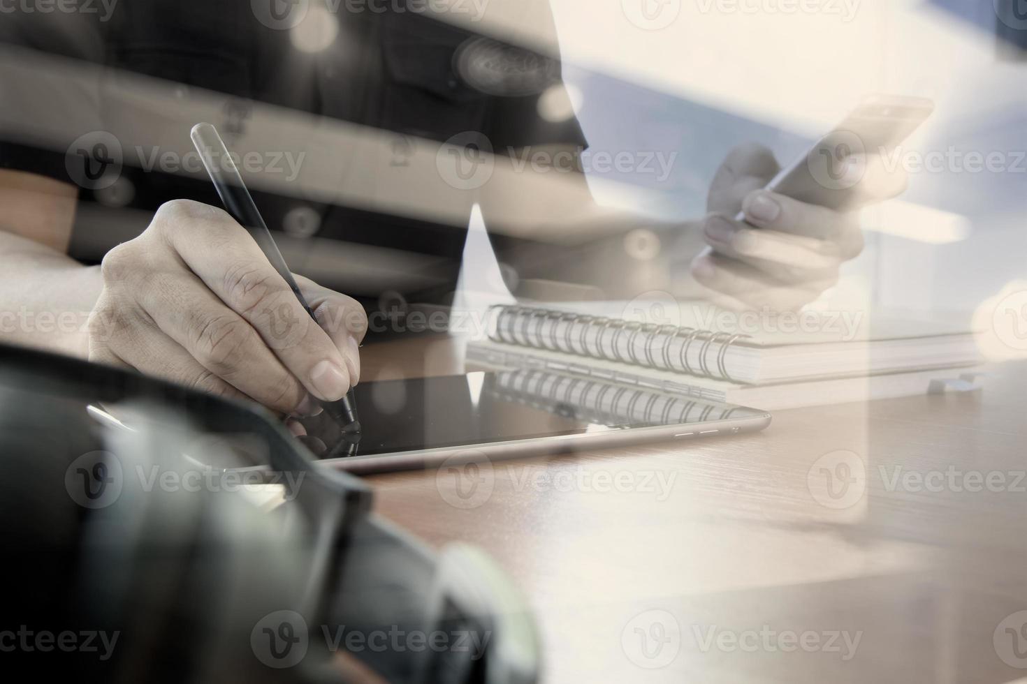 designer hand working with digital tablet and laptop and notebook stack and eye glass on wooden desk in office with social media diagram photo