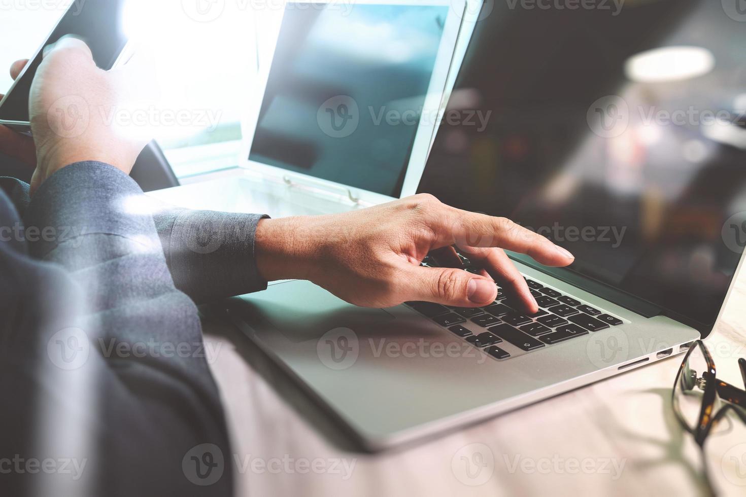 Website designer working digital tablet and computer laptop with smart phone and graphics design diagram on marble desk as concept photo