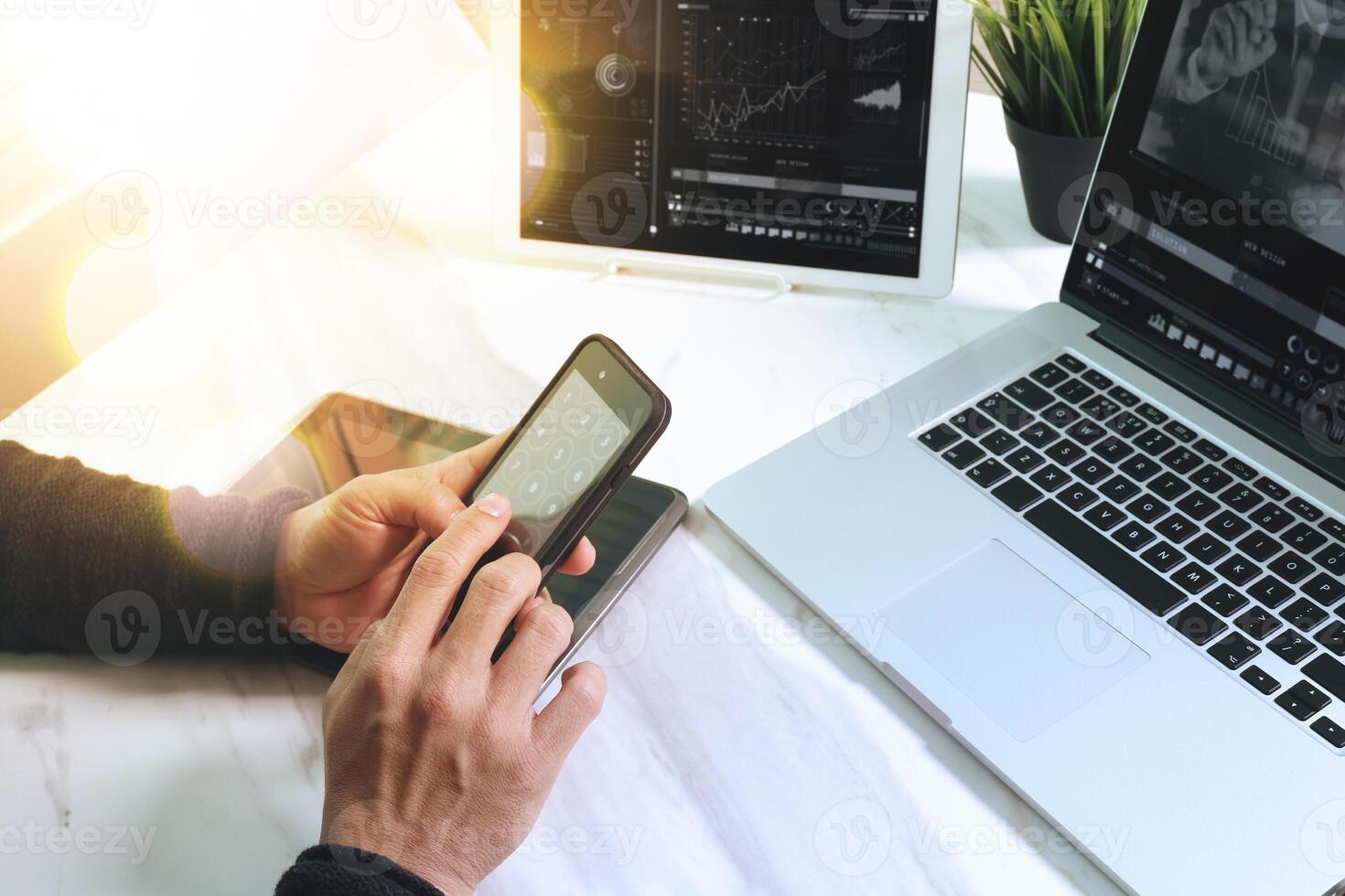 concepto de trabajo en equipo, mano de hombre de negocios asistiendo a videoconferencia en la oficina moderna. uso de teléfono inteligente de diseño de computadora portátil de tableta digital. efectos del sol foto