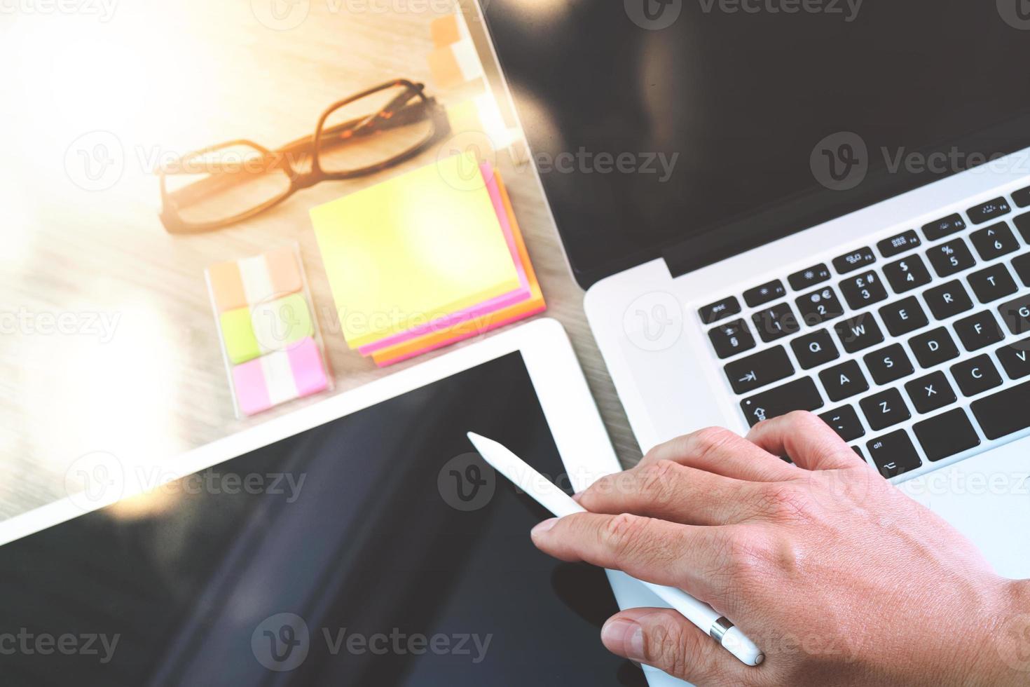 businessman working with digital tablet computer and memo note and laptop computer with digital business strategy layer effect on wooden desk as concept photo