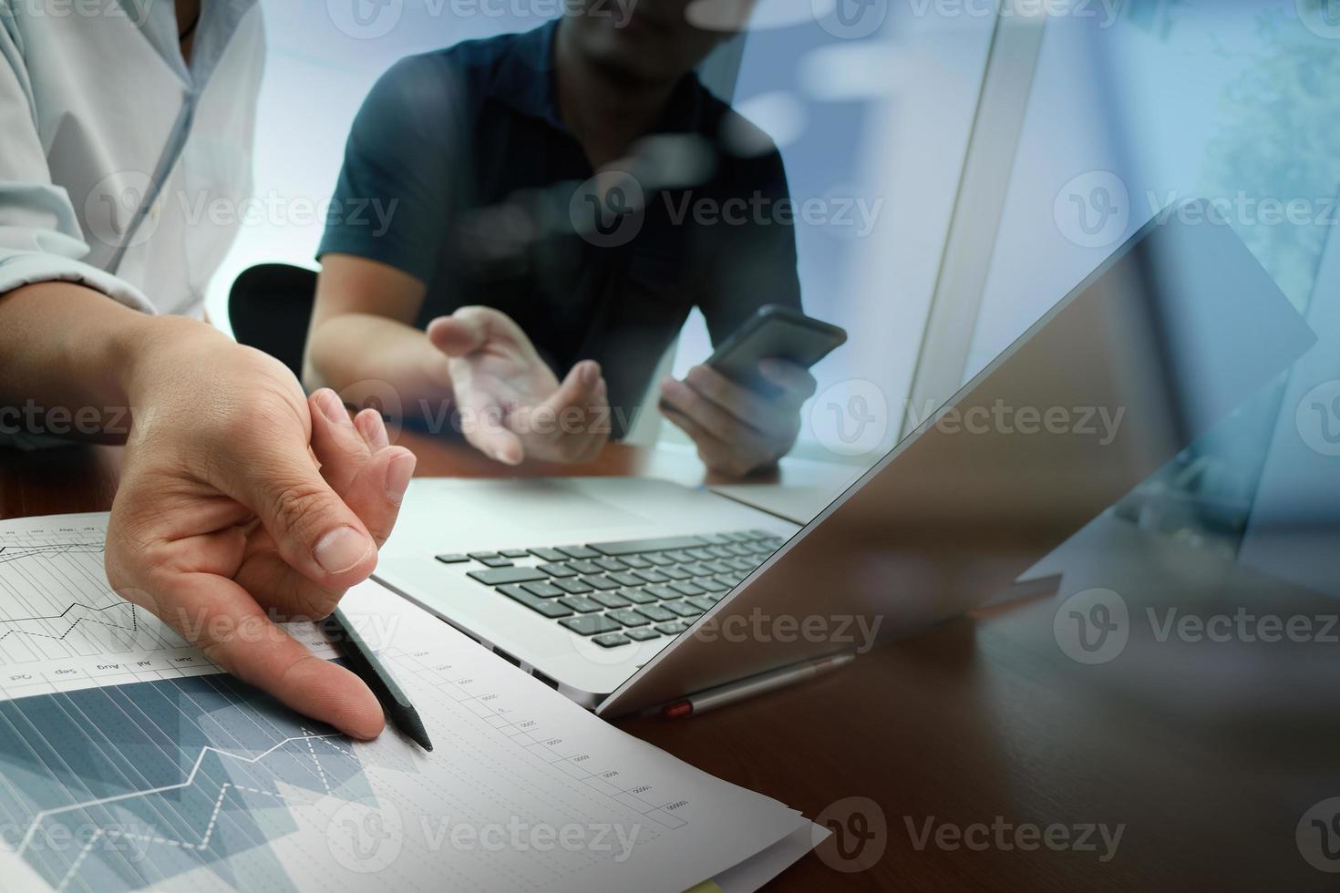 business documents on office table with smart phone and digital tablet and graph business diagram and man working in the background photo