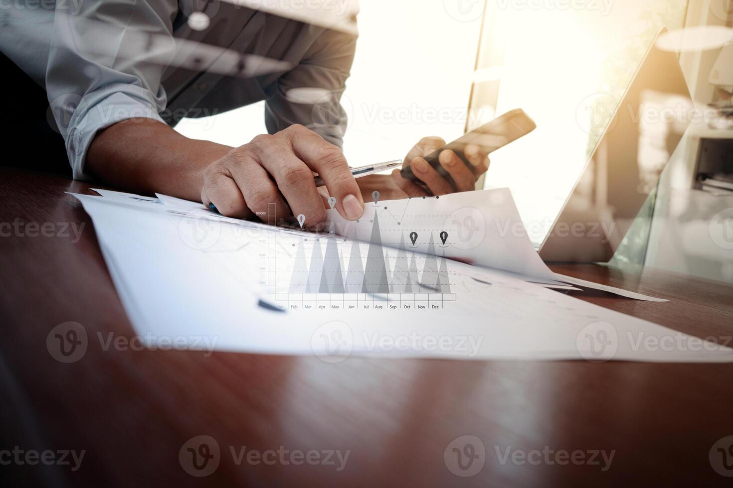 business documents on office table with smart phone and laptop computer and graph business with social network diagram and man working in the background photo