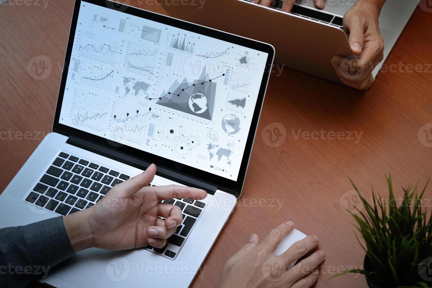 top view of two colleagues discussing data with new modern computer laptop with business strategy document and digital diagram as concept photo