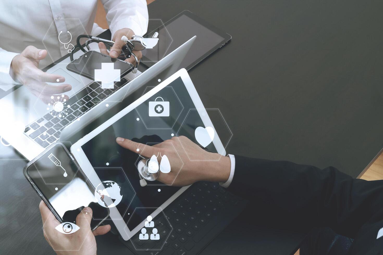 Medical co working concept,Doctor working with smart phone and digital tablet and laptop computer to meeting his team in modern office at hospital photo