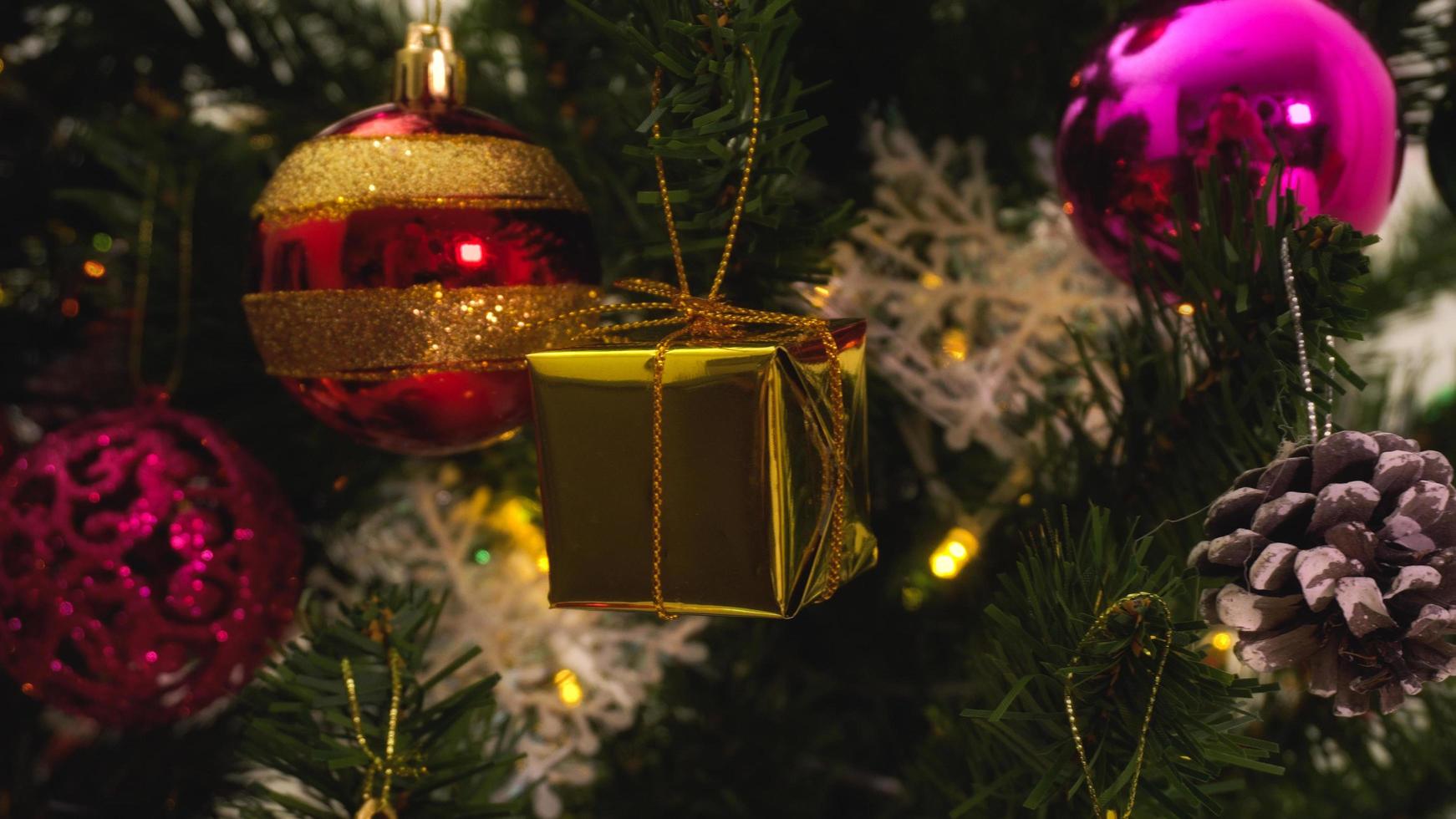 concepto de temporada de saludo.cierre de adornos en un árbol de navidad con luz decorativa foto