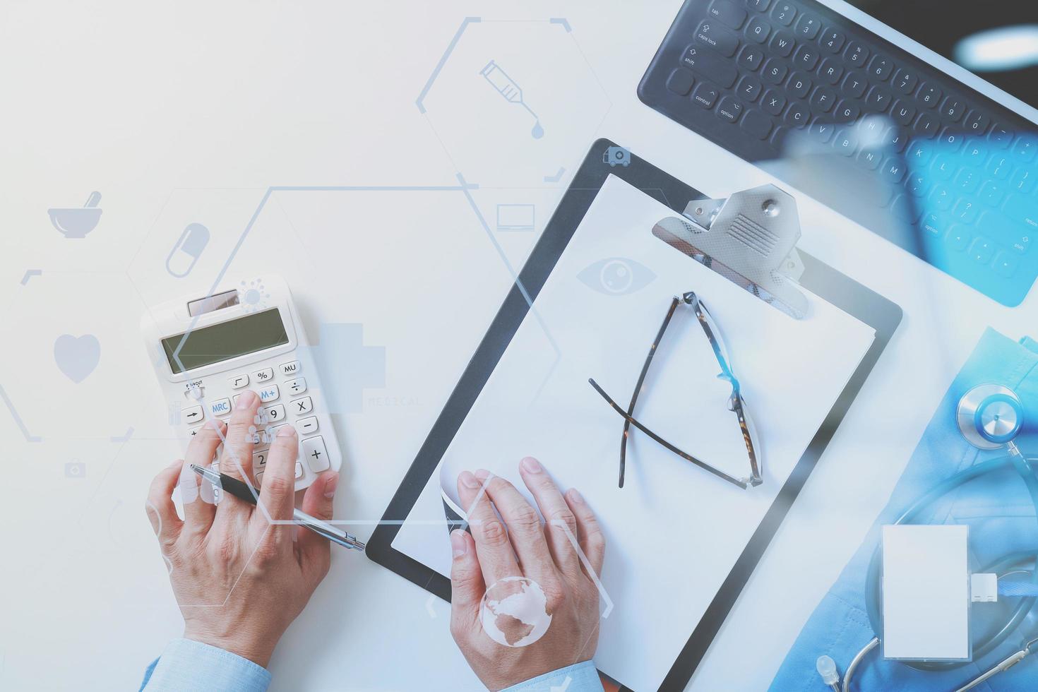 top view of Healthcare costs and fees concept.Hand of smart doctor used a calculator for medical costs in modern hospital with VR icon diagram photo