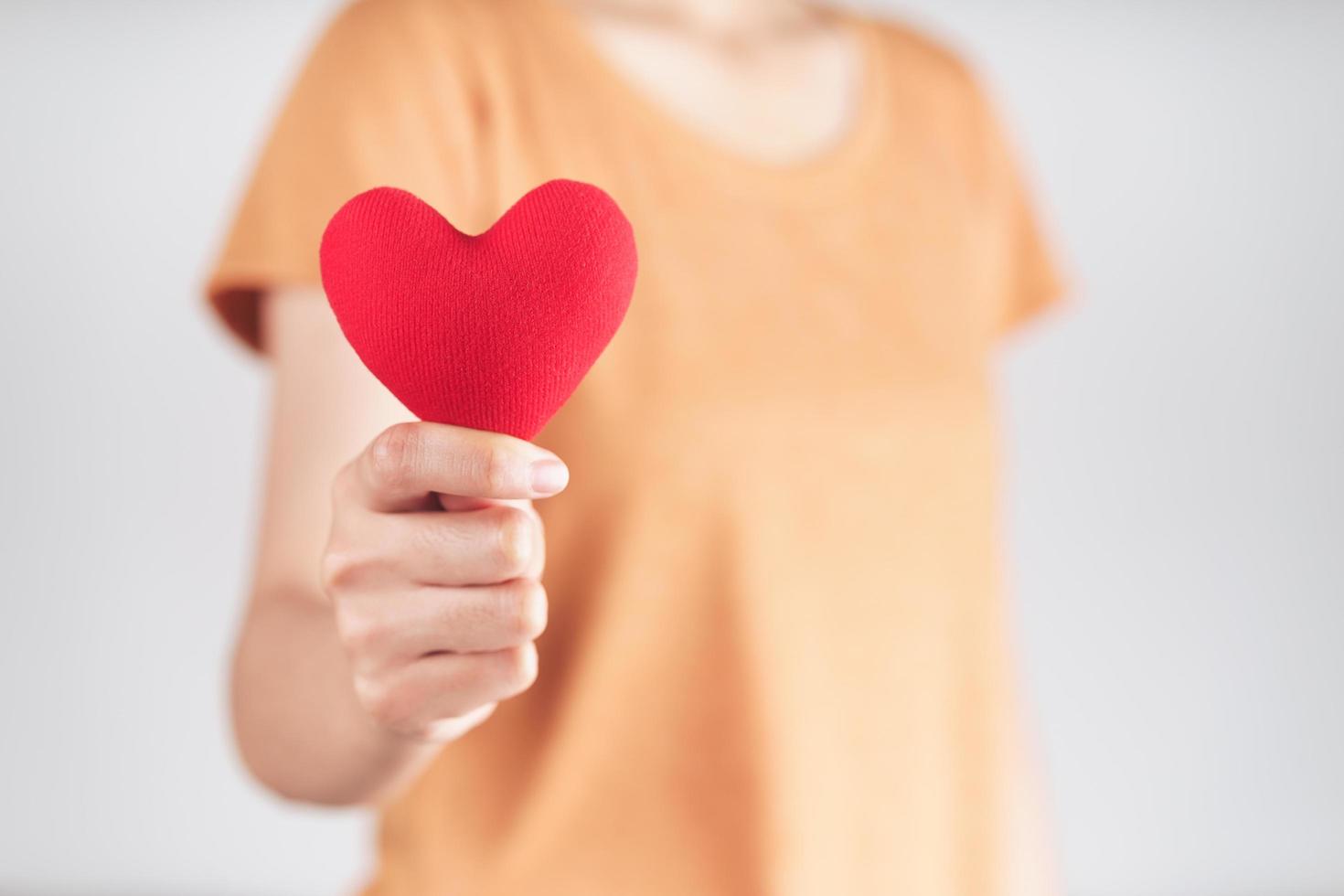 mujer sosteniendo un corazón rojo, amor, seguro médico, donación, feliz voluntario de caridad, día mundial de la salud mental, día mundial del corazón, día de san valentín foto