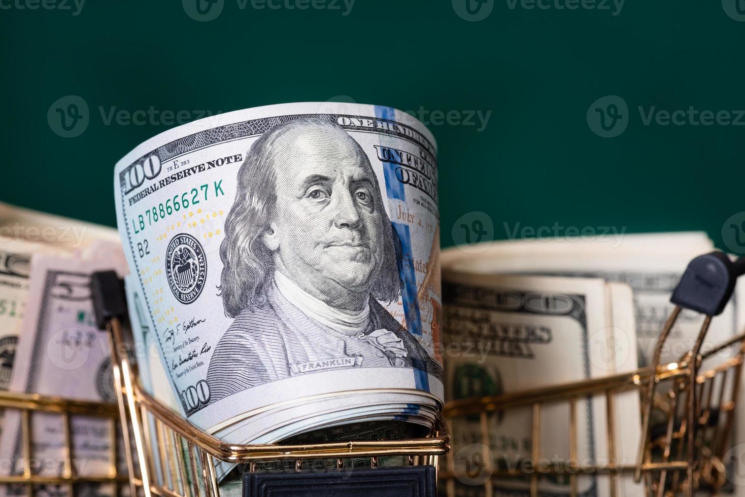 Three shopping carts with paper banknotes on a dark green background. Finance, banks. photo