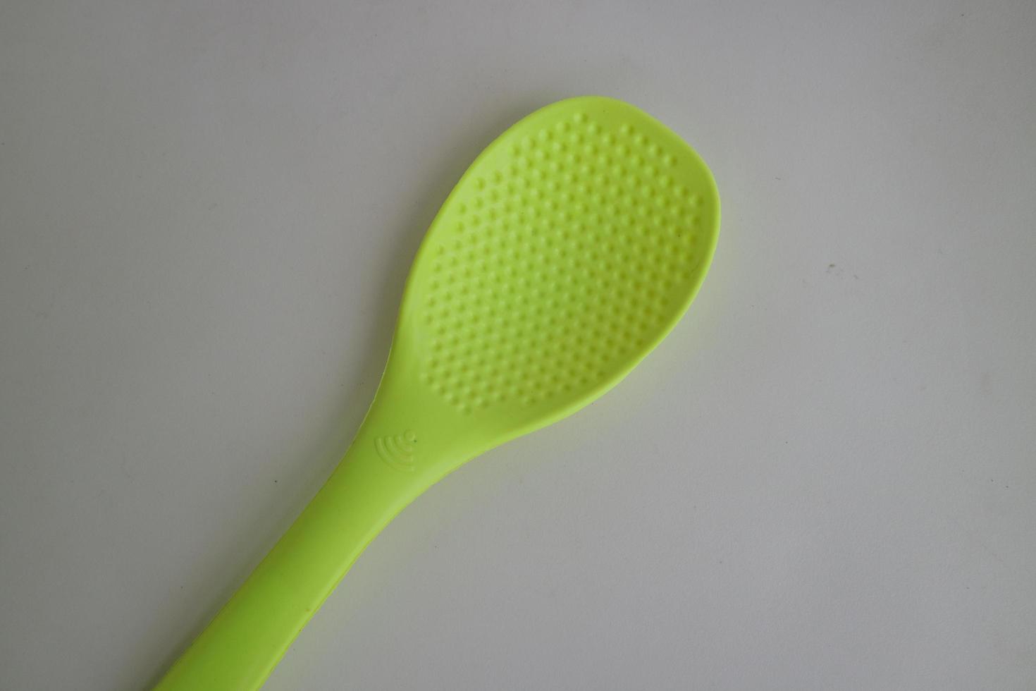 green rice spoon on white background photo