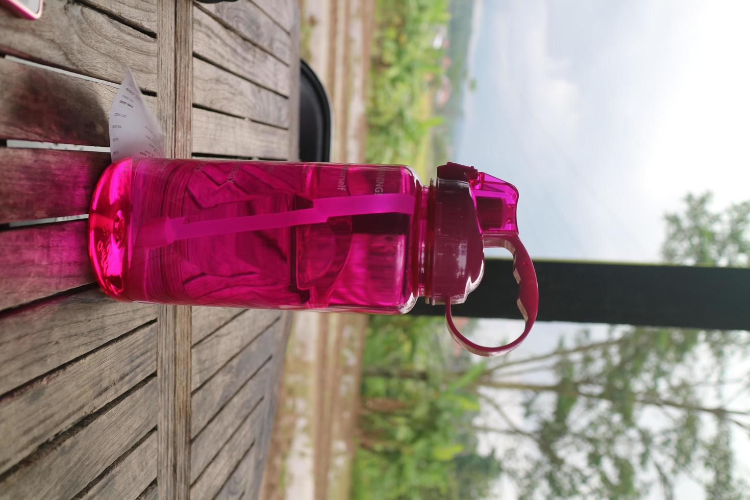 big purple bottle on the wooden table photo