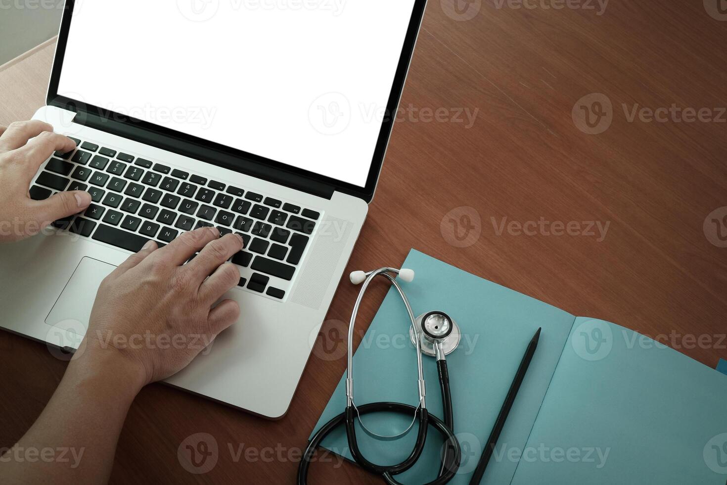 top view of Medicine doctor hand working with modern computer and smart phone on wooden desk as medical concept photo