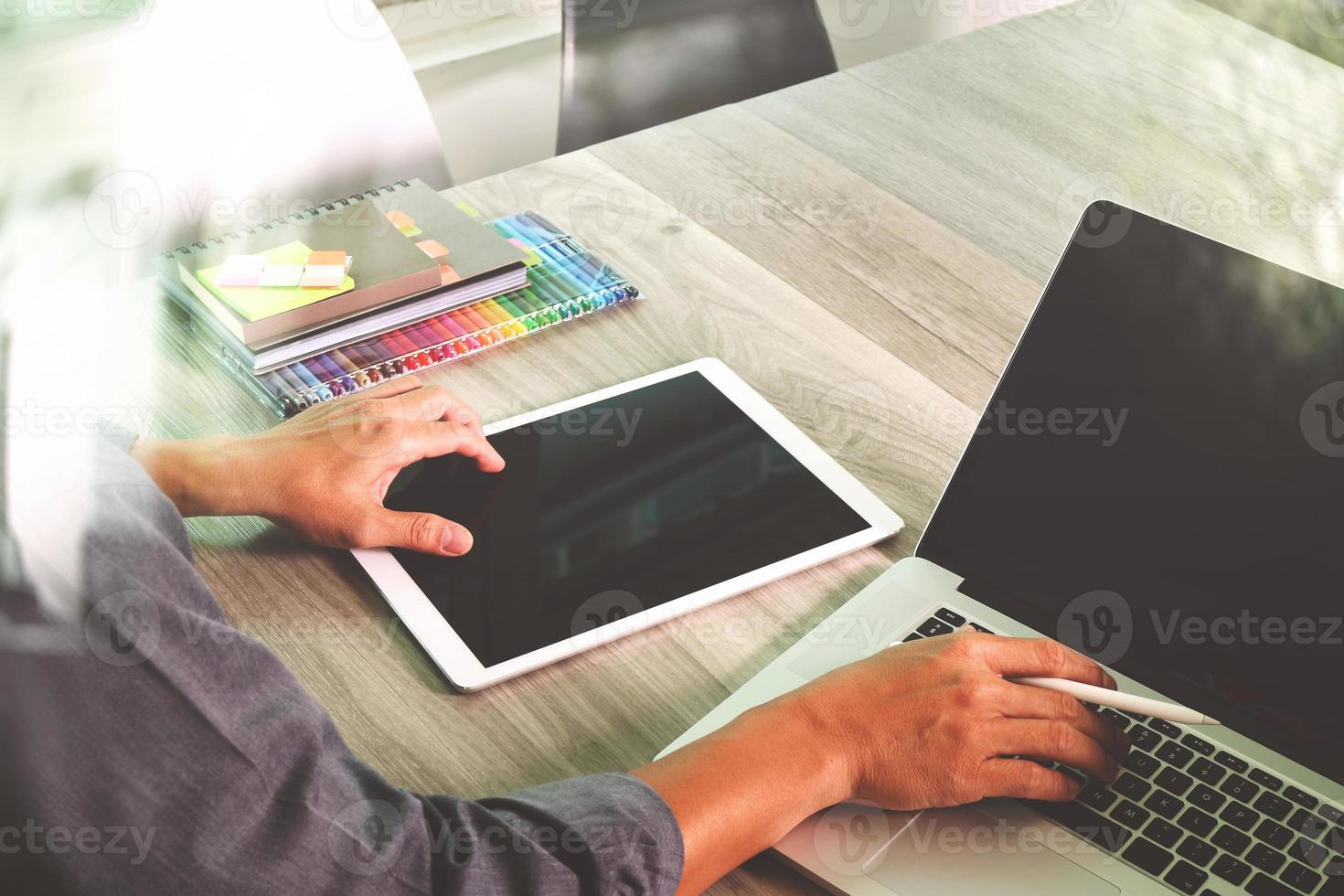 mano de hombre de negocios trabajando en una computadora portátil con pantalla en blanco y una tableta digital y un teléfono inteligente en un escritorio de madera como concepto foto