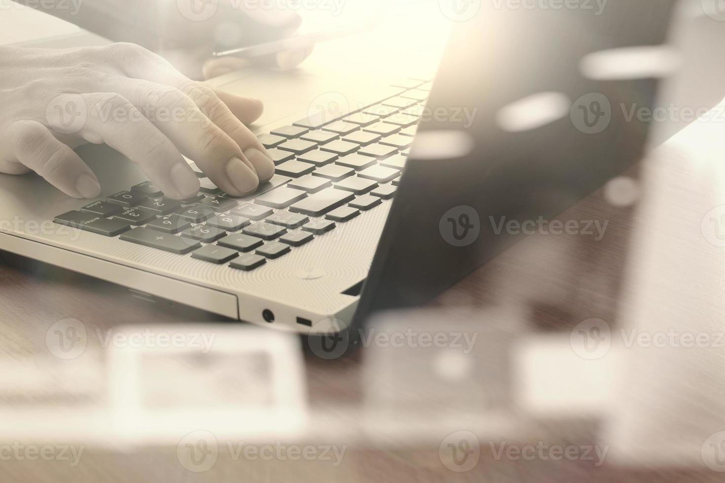 primer plano de la mano del hombre de negocios que trabaja en una computadora portátil con un diagrama de red social en un escritorio de madera como concepto foto