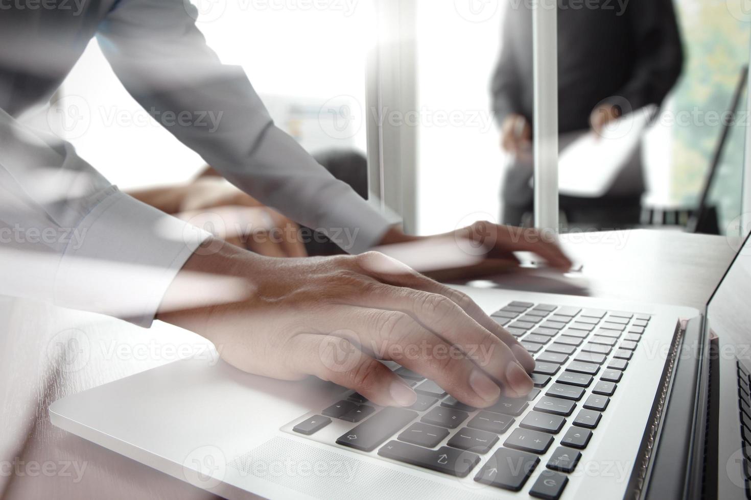 primer plano de la mano del hombre de negocios que trabaja en una computadora portátil con un diagrama de red social en un escritorio de madera como concepto foto