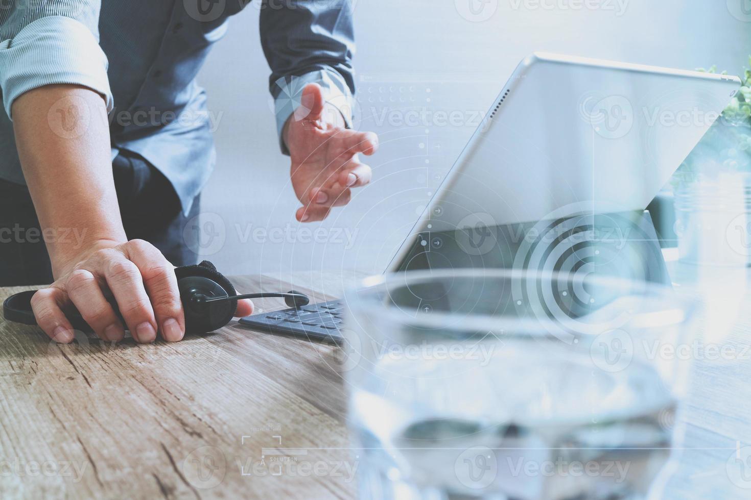 Man using VOIP headset with digital tablet computer docking smart keyboard, concept communication, it support, call center,digital screen graphic virtual icons,graph,diagram photo