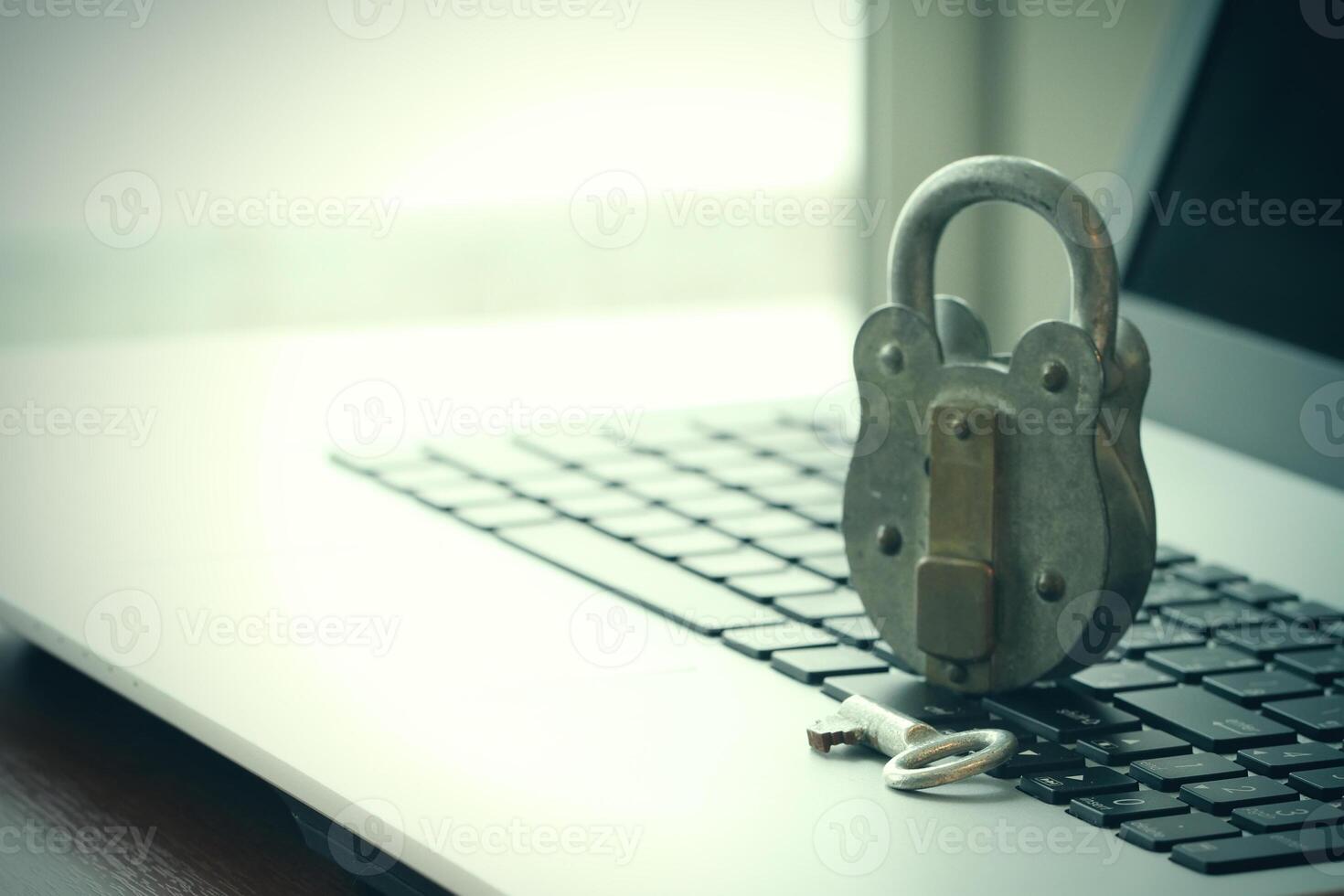 concepto de seguridad en Internet: candado antiguo y llave en el teclado de la computadora portátil foto