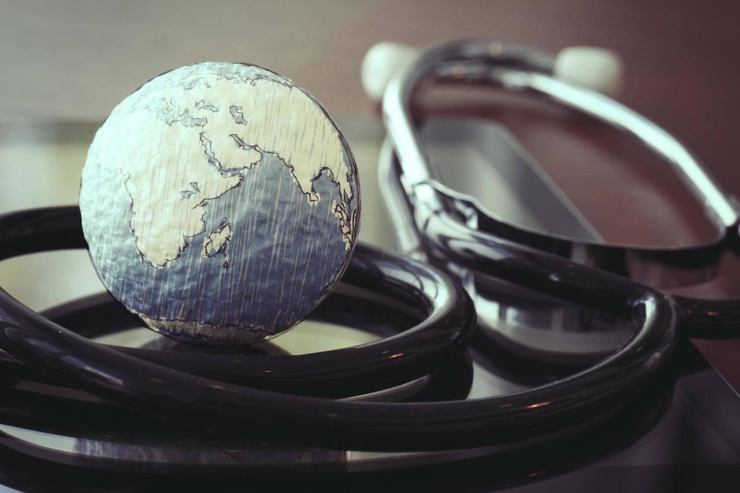 stethoscope and texture globe with digital tablet as medical network concept photo