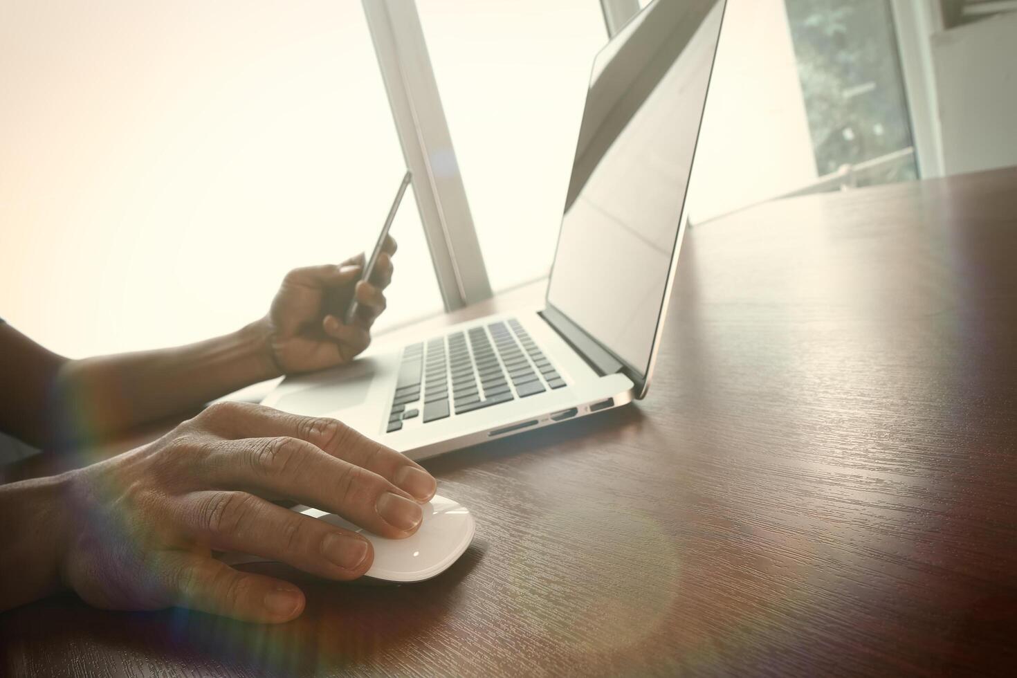 business man hand working on laptop computer on wooden desk photo