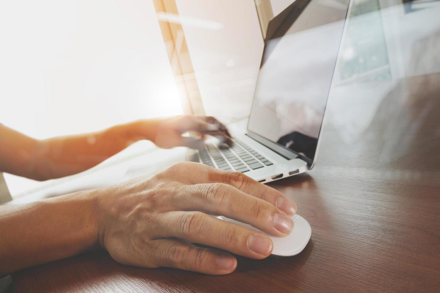 mano de hombre de negocios trabajando en una computadora portátil de pantalla en blanco en un escritorio de madera como concepto foto