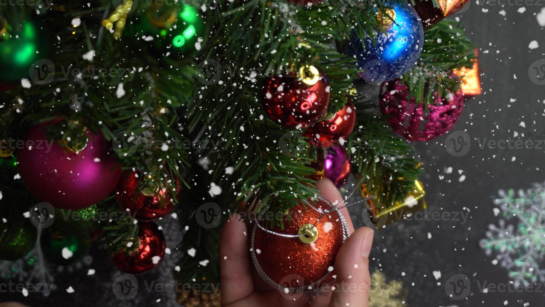 concepto de temporada de saludo ajuste manual de adornos en un árbol de navidad con luz decorativa foto