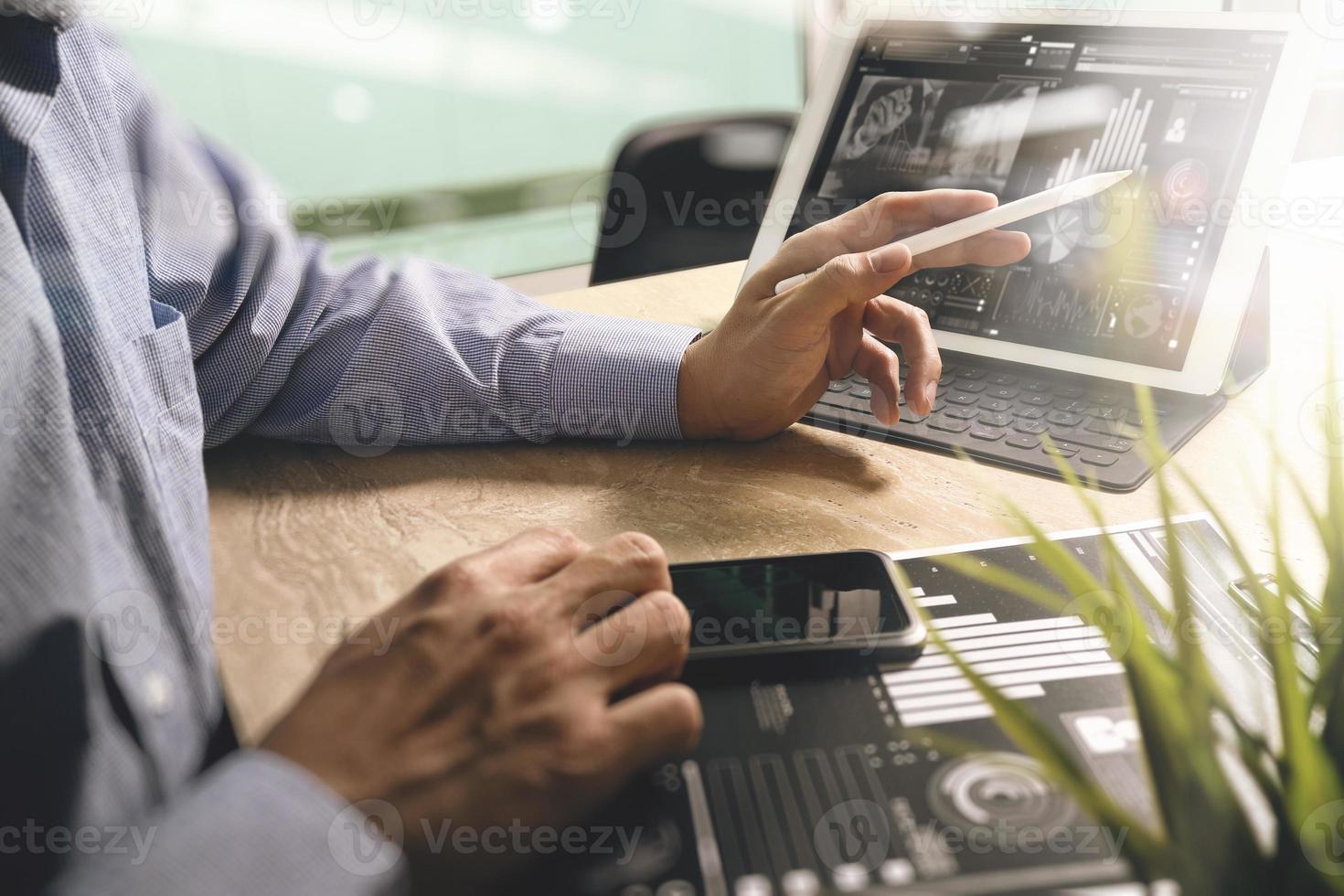 Businessman hand working concept. Documents finance graphic chart. Digital tablet keyboard dock screen computer design smart phone using. Eyeglass on marble desk. Sun flare effect photo