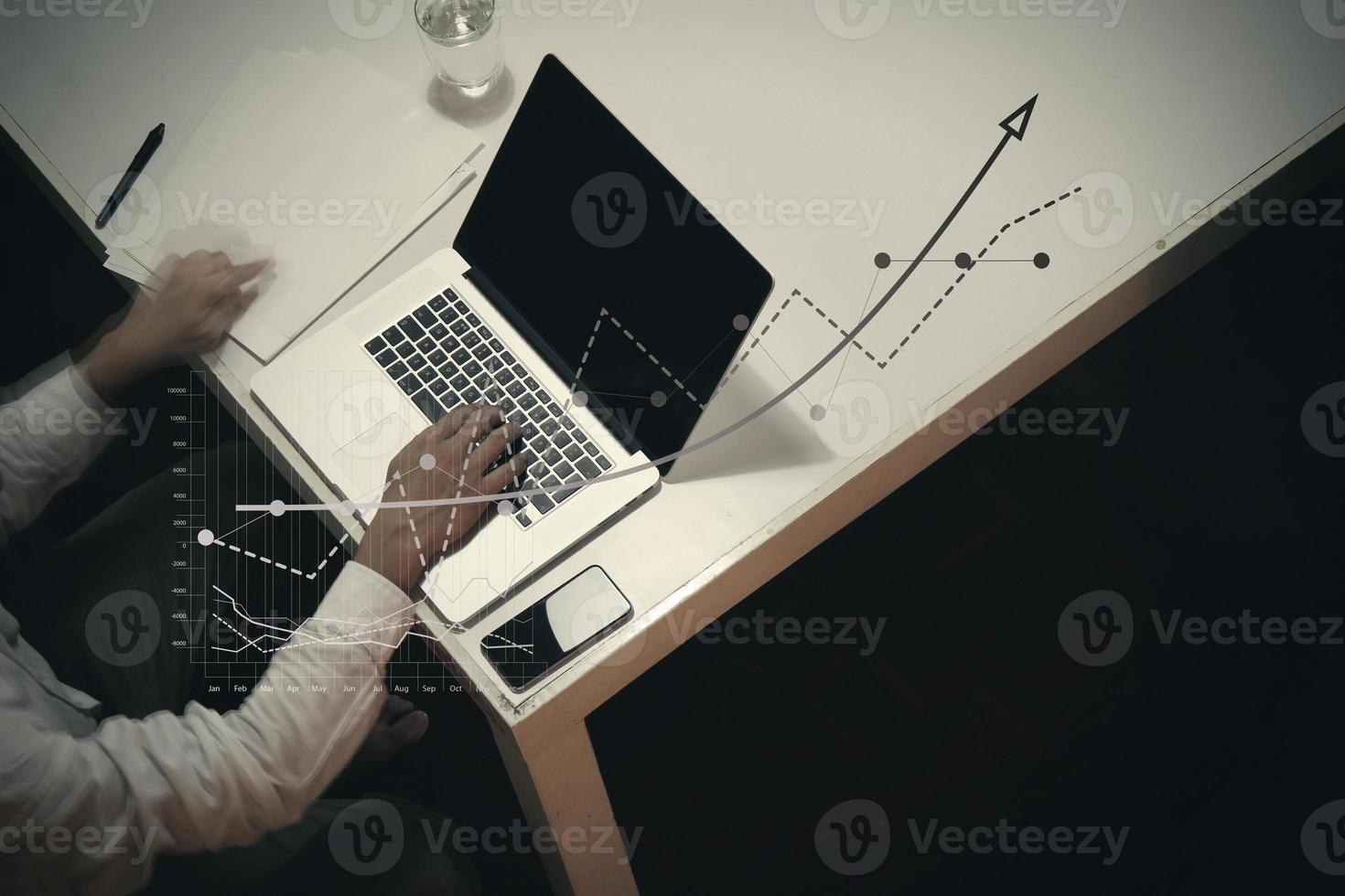 top view of man working with business documents on office table with digital tablet and man working with smart laptop computer photo