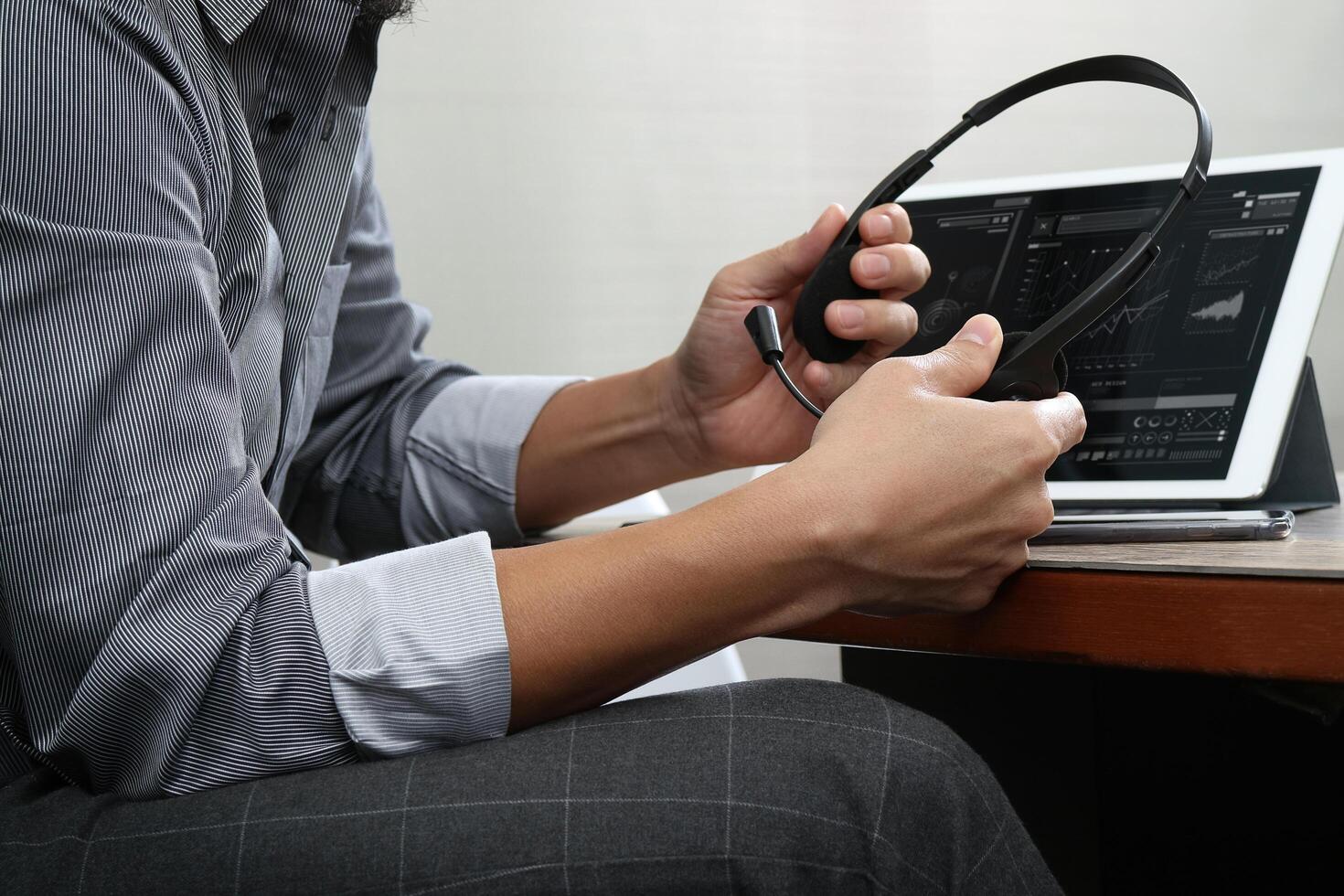 business man using VOIP headset with digital tablet computer docking smart keyboard, concept communication, it support,on wood desk photo