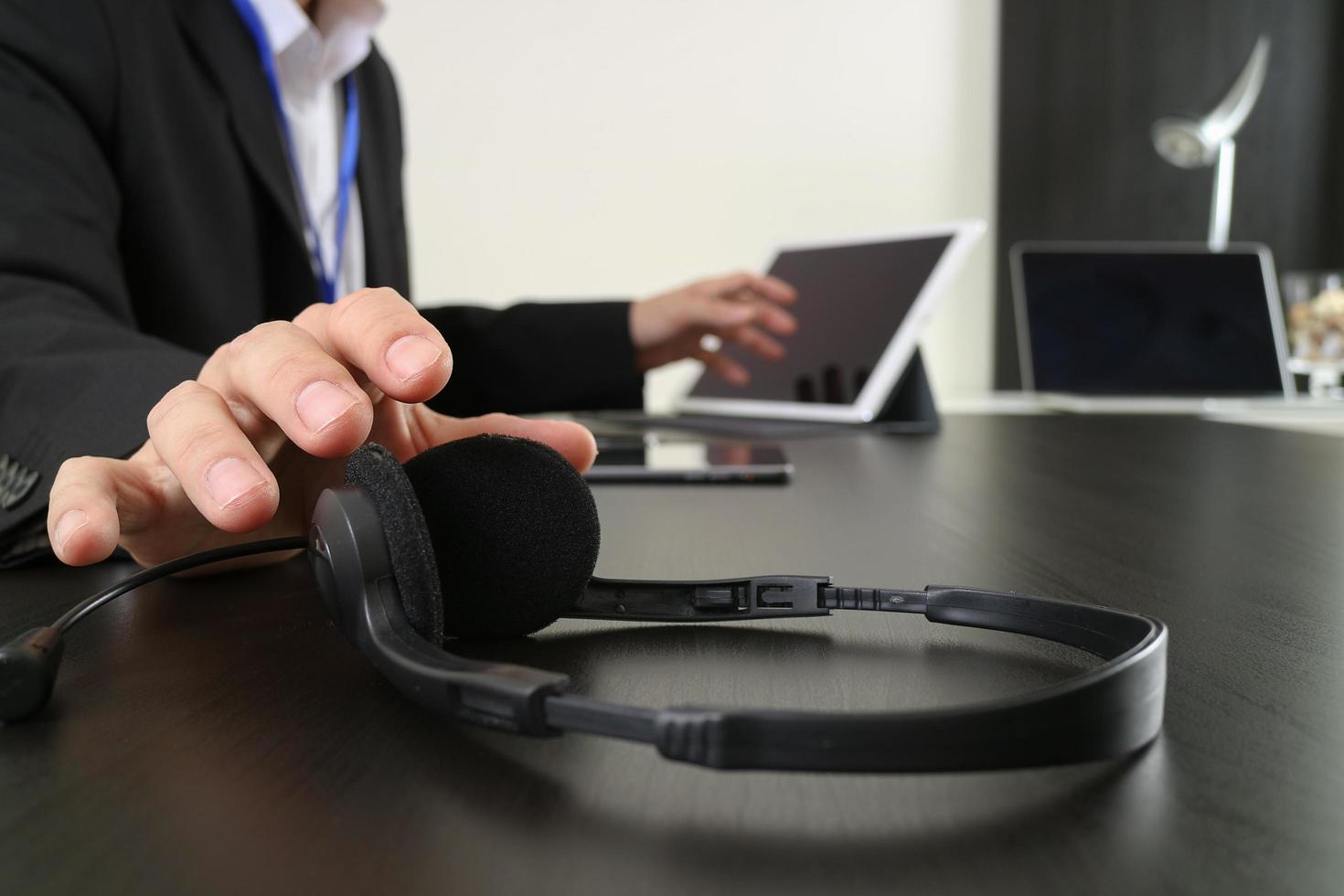 hombre que usa auriculares voip con tableta digital y computadora portátil como concepto de comunicación, soporte, centro de llamadas y servicio de atención al cliente foto