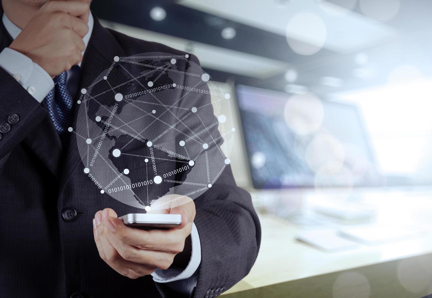 Businessman hand using  mobile phone with social network diagram on wooden desk as concept photo