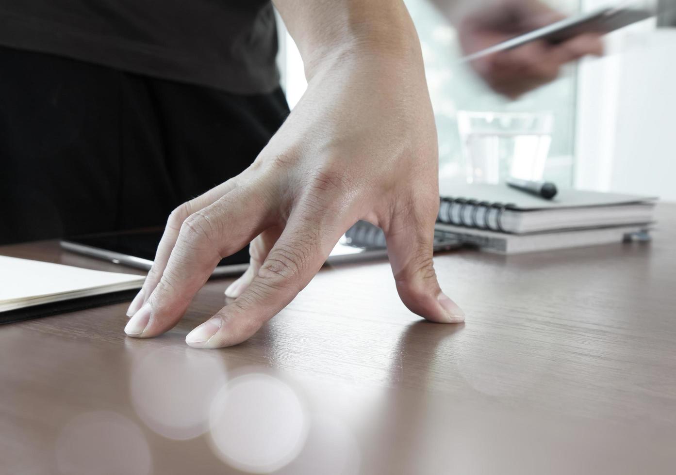 mano de hombre de negocios usando una computadora portátil y un teléfono móvil en un escritorio de madera como concepto foto