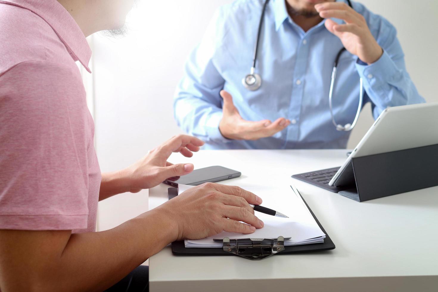 Medical doctor using mobile phone and consulting businessman patient having exam as Hospital professionalism concept photo