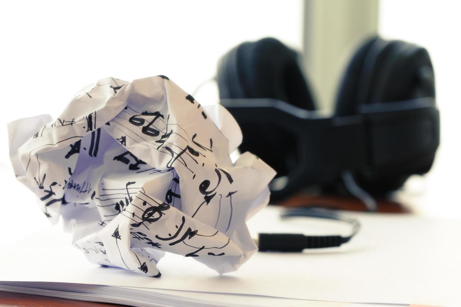 composing music concept with shallow DOF evenly matched jack of headphone and crumpled musical notes paper photo