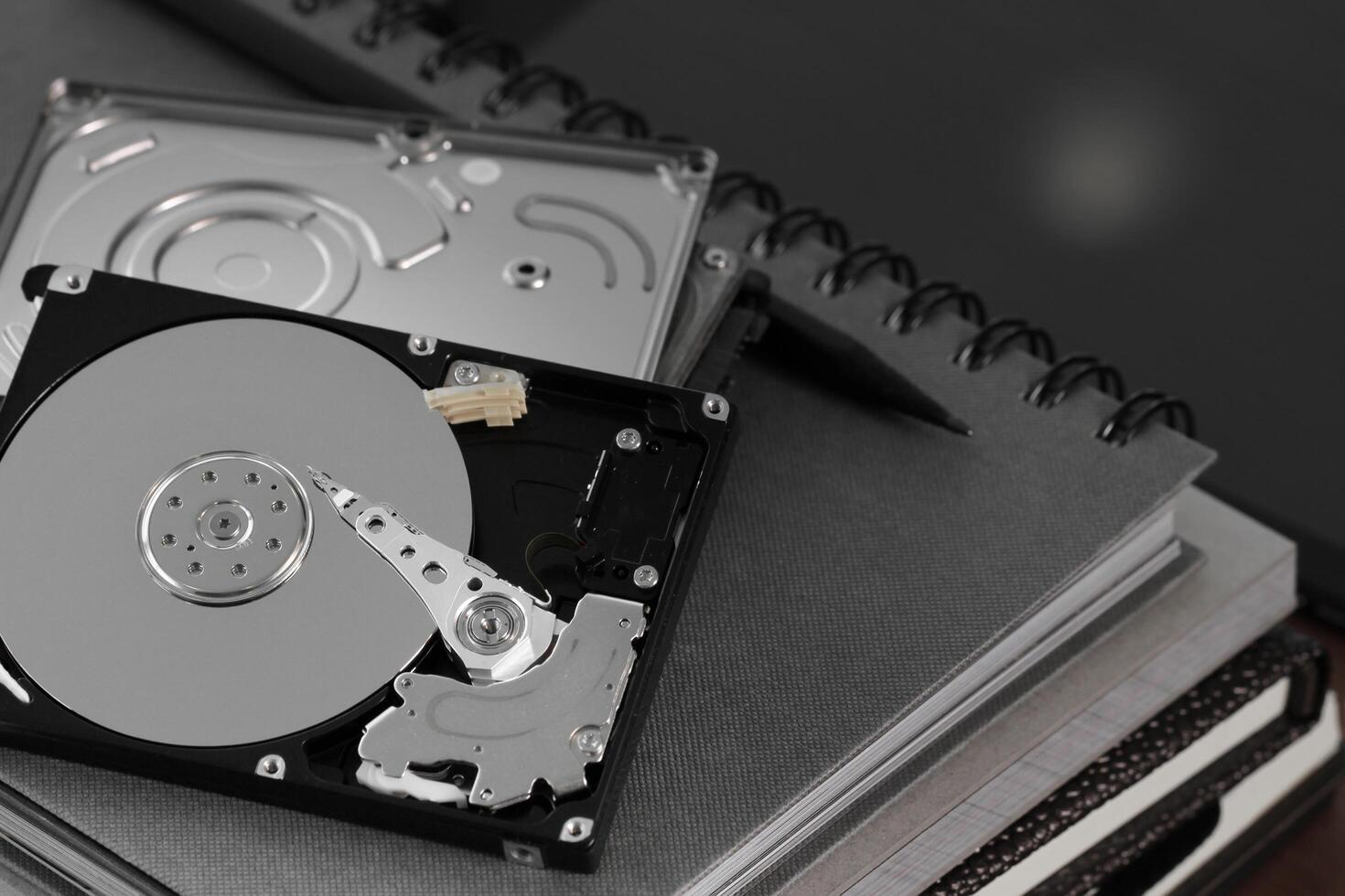 Close up of open computer hard disk drive on desk and notebook photo