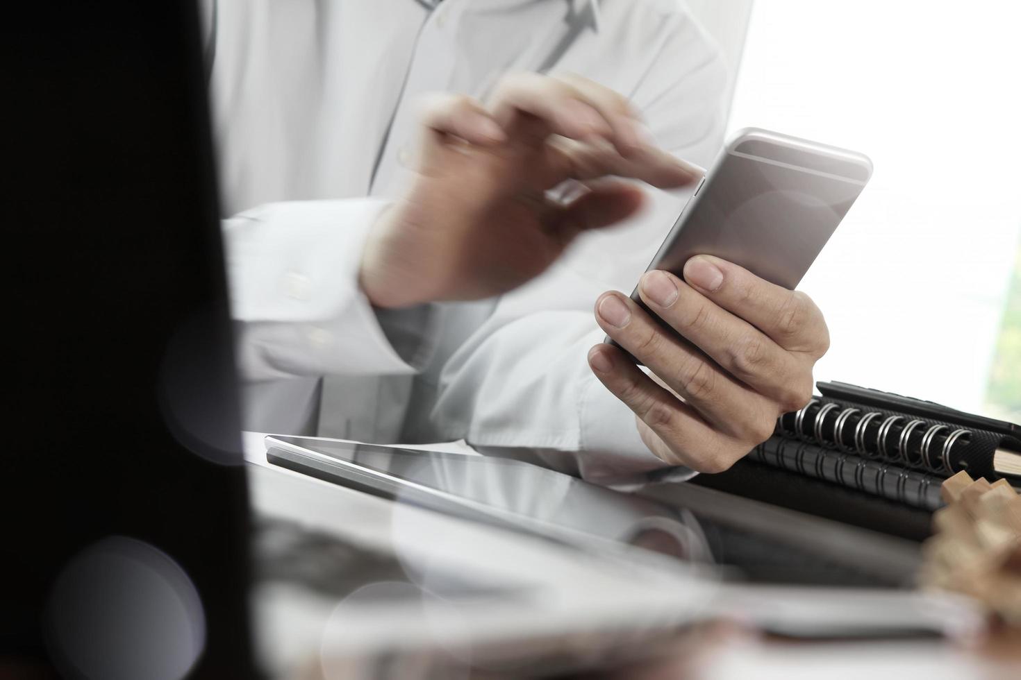 Businessman hand using laptop and mobile phone on wooden desk as concept photo