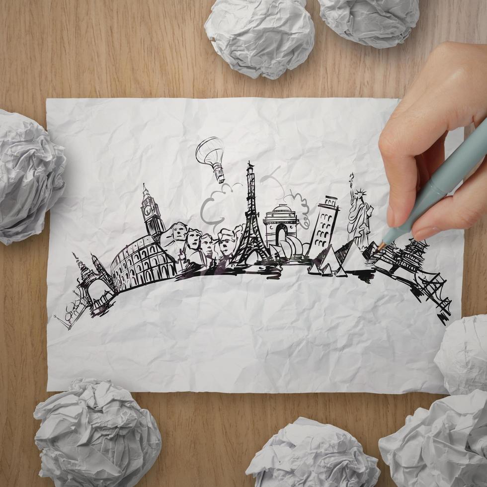 crumpled paper with hand drawn traveling around the world on wooden background as concept photo