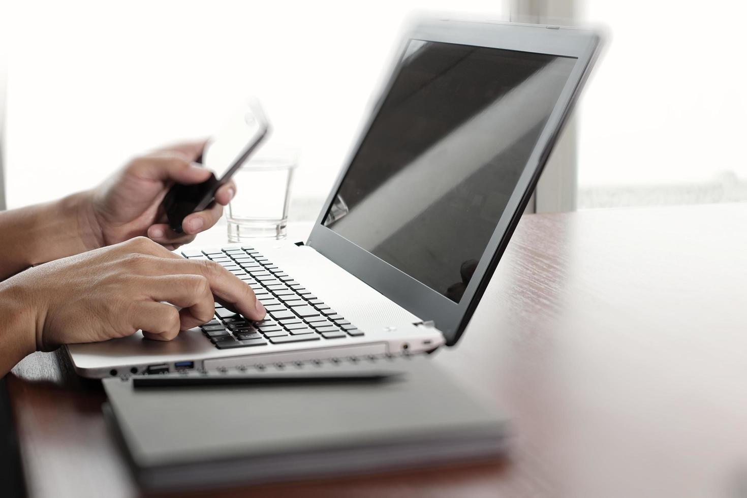 Close up of business man working on laptop computer on wooden desk as concept photo