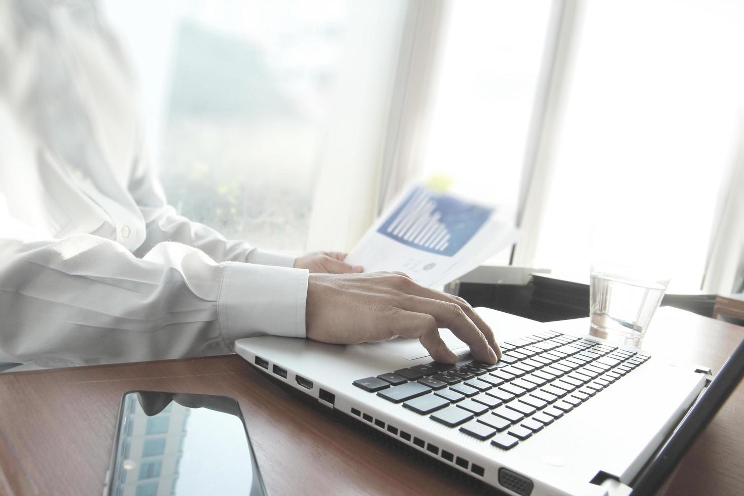 business man hand working on laptop computer on wooden desk as concept photo