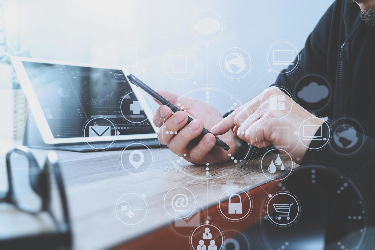 businessman hand using smart phone,mobile payments online shopping,omni channel,digital tablet docking keyboard computer in modern office on wooden desk,virtual interface computer screen photo