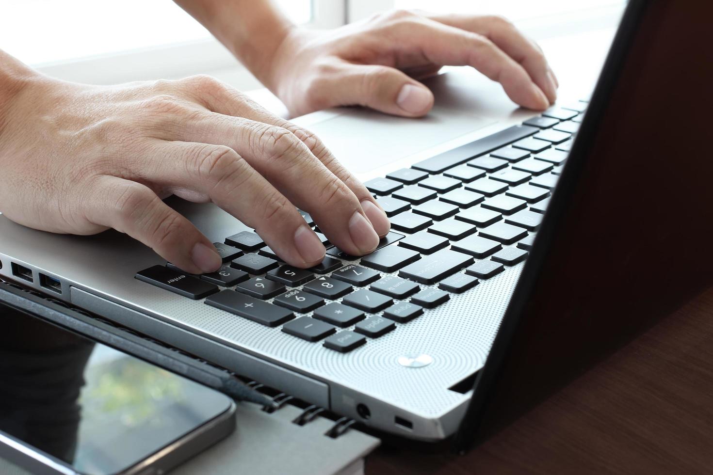 Close up of business man hand working on  laptop computer on wooden desk as concept photo