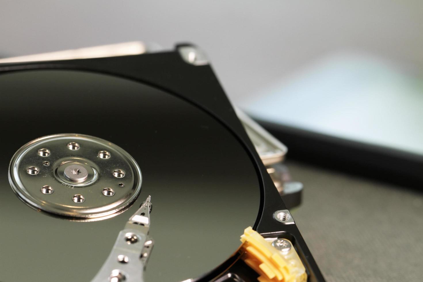 Close up of open computer hard disk drive on desk and notebook photo