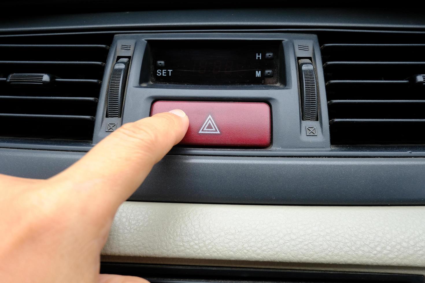 dedo índice o índice empujando el botón de parada de emergencia rojo del coche concepto de seguridad de advertencia foto