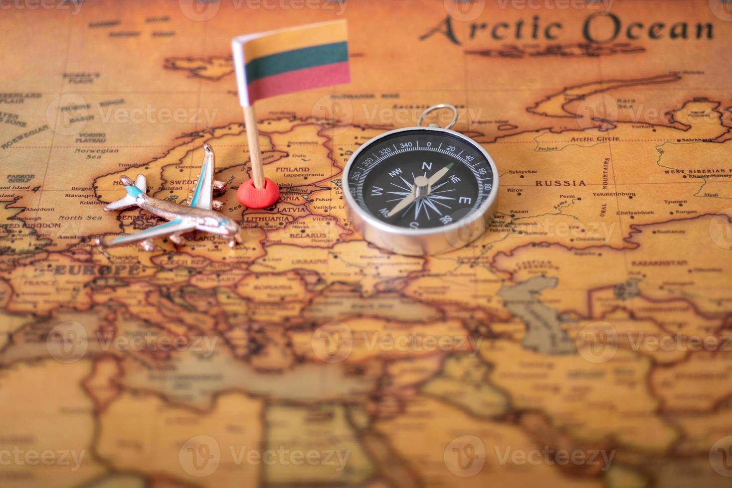 Lithuanian flag, compass and airplane world map. photo
