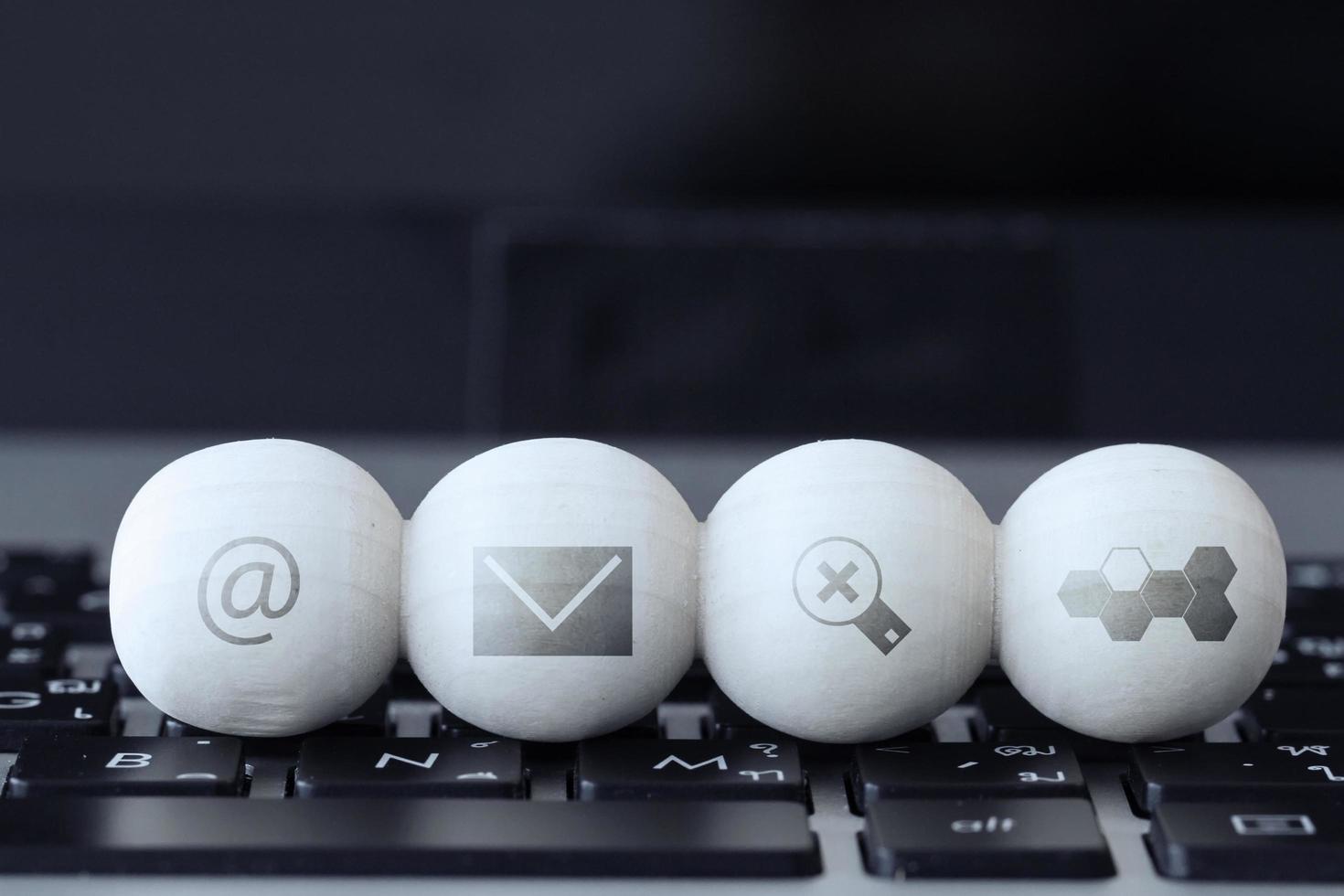 internet concept icons on wooden balls and laptop computer photo