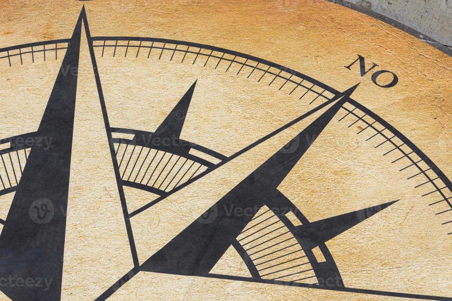 The compass is drawn on a concrete slab. photo